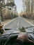 One man pov or his hands driving a vehicle on a long scenic trees asphalt road. Traveling and driving camper van truck. Freedom