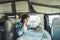 One man reading road map inside a modern camper van motorhome to choose best trip. Traveler people with vehicle. Alternative home