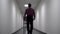 One man walks down the long white corridor. Blurred background. Video contains flicker and noise.