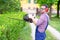 One man working in garden and shaping bush using hedge trimmer