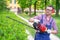 One man working in garden and shaping bush using hedge trimmer