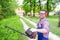 One man working in garden and shaping bush using hedge trimmer