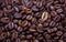 One of many. Gold coffee bean on a pile of coffee beans. The concept of luxury. Coffee beans texture background.
