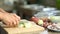 One more ingredient, Closeup of male arms chopping vegetables with knife