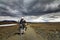 One Motorbiker Man driving on a gravel road in Kaldidalur desert. Motorcycle Adventure in Iceland.