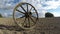 One old broken wooden horse carriage wheel on field and clouds motion. Timelapse 4K