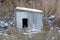 One old empty wooden doghouse stands on a winter street