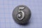 One old gray button with number five