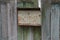 One old gray metal mailbox in rust hangs on wooden boards