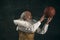 One old man, actor having fun, playing with basketball ball isolated on dark vintage background. Retro style, comparison