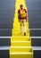 One old man of European nationality walks up the bright yellow steps, Solo Travellers