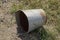 One old rusty empty metal bucket lies on the ground