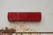 One old small rectangular red plastic turn signal reflector on white car metal