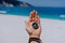 One open stretched hand palm with black metal compass on the sandy beach. Find your wish goal way concept. Blue sea in