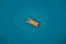 one orange clothespin isolated on blue background