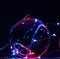 One perfect glass ball is illuminated by coloured lights