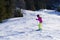 One person in bright clothes goes downhill on skis at a ski resort. Winter recreation, sports or training time. Person goes down