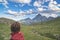 One person looking at the majestic view of glowing mountain peaks at sunset high up on the Alps. Rear view, toned and filtered ima