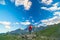 One person looking at the majestic view of glowing mountain peaks at sunset high up on the Alps. Rear wide angle view, toned and f