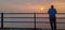 One person looking at sunrise by residing on railing