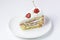 One piece of vanilla cherry cake on a white plate over white background. Delicious sweet dessert close up.