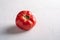 One pink heirloom tomato vegetable, fresh red ripe tomatoes, vegan food, white stone concrete background