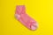 one pink sock on a yellow background