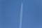 One plane leaves contrails trace in a clear blue sky.