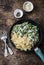 One pot creamy chicken spinach and green peas farfalle pasta in the pan on brown wooden background
