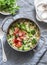 One pot orzo primavera. Orzo pasta with asparagus, broccoli, green peas and cream in a saucepan. On a light background