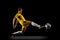 One profession young male football player training on black backround