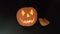 One pumpkin on Halloween with a sinister expression on a black background