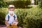 One pupil boy wearing mask is sitting on bench near his school during covid-19 pandemic time. New normal and education concept of