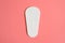 One pure empty women`s disposable daily menstrual sanitary pad or napkin on pink background.