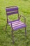 One purple chair on a green lawn. The concept of free vacancy, loneliness, desolation. For the image of empty public