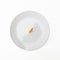 One raw uncoocked fusilli pasta on white ceramic plate isolated on white, slimming mediterranean diet concept