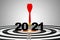 One red dart arrow hit on 2021 of  centre target of dartboard. It is symbol for business hitting to achieve target in 2021 year