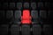 One red empty seat among others black seats in cinema hall