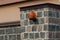 One red plastic signal light hanging on a stone gray brown fence