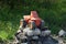 One red plastic toy car with black wheels stands on a heap of gray stones