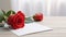 one red rose and white paper on the wooden table, bright blur background