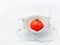 One red tomato in a medical anti covid mask on a white background
