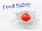 One red tomato in a medical anti covid mask on a white background with food safety inscription
