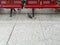 One row of red empty seats on a light spotted floor and a dove under the chairs. Beautiful background with copy space of bird in