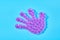 One rubber toy child palm with many suction cups on blue background. Symbol of friendship