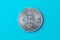 One silver bitcoin on blue background. E-commerce, cryptocurrency. Blockchain, international mining