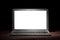 One silver modern laptop with empty white screen on wooden table in a dark room on black background. Nice mockup for your IT