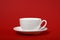 One simple coffee cup on red color background, closeup photo