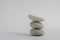 One simplicity stones cairn isolated on white background, group of light three white pebbles in tower