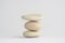 One simplicity stones cairn isolated on white background, group of light three white pebbles in tower